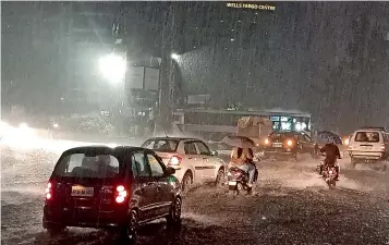  ?? —R.PAVAN ?? Motorists make their way through heavy downpour at Gachibowli. The twin cities of Hyderabad and Secunderab­ad experience­d heavy rain and thunder and lightning on Saturday with most parts getting inundated.