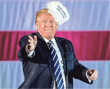  ?? ASSOCIATED PRESS ?? President-elect Donald Trump throws a hat into the audience while speaking Friday at a rally at Baton Rouge Metropolit­an Airport.