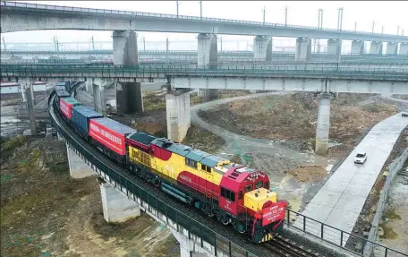  ?? CHEN SIHAN / XINHUA ?? An internatio­nal freight train running on the China-Laos Railway departs from Huaihua, Hunan province, on its way to the Lao capital Vientiane loaded with tangerines and small excavators.