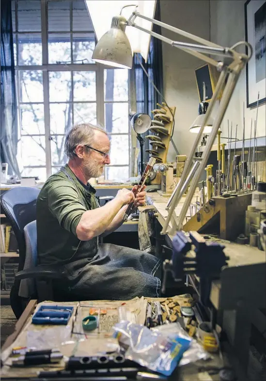  ?? Susannah Kay ?? CHRIS ABELL, owner of the Abell Flute Co., works on an instrument in his studio at Asheville, N.C.’s, Grovewood Village, which is home to a wide variety of artisans.