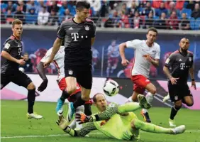  ?? Associated Press ?? Bayern's Robert Lewandowsk­i, second left, challenges for the ball with Leipzig goalkeeper Peter Gulacsi, third right, on Saturday during the German first division Bundesliga soccer match between RB Leipzig and FC Bayern Munich in Leipzig, Germany.