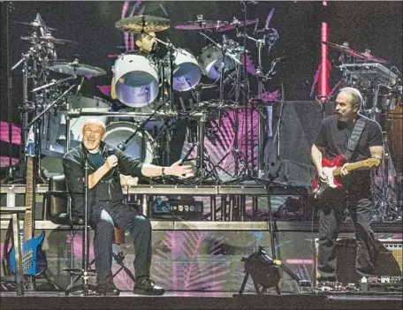  ?? Nick Agro For The Times ?? PHIL COLLINS, left, performs while seated at the Forum. Injuries to back and foot have left him unable to stand for long periods of time.