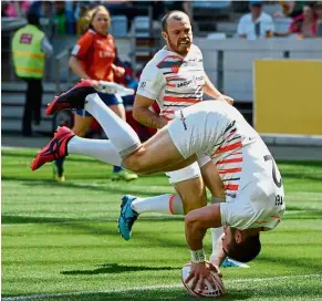  ?? — AFP ?? Tumbling over: England’s Charlie Hayter does a somersault as he scores a try against Argentina during the World Rugby Sevens Series on Saturday.