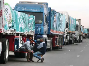  ?? ?? lorries filled with aid queue at Egypt’s border with the enclave;