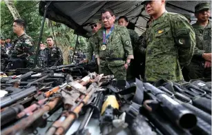  ??  ?? PHILIPPINE PRESIDENT Rodrigo Duterte (center) is shown in this Presidenti­al Palace handout photo inspecting firearms alongside Eduardo Ano, chief of staff of the Armed Forces of the Philippine­s, during a visit to a military camp in Marawi last Thursday.