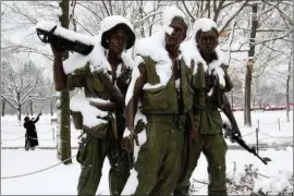  ?? The Associated Press ?? THE THREE SOLDIERS: The Three Soldiers sculpture is covered in snow at the Vietnam Veterans Memorial during a snowstorm Sunday as a partial government shutdown stretches into its third week at Capitol Hill in Washington. With the standoff over paying for his long-promised border wall dragging on, the president’s Oval Office address and visit to the Texas border over the past week failed to break the logjam and left aides and allies fearful that the president has misjudged Democratic resolve and is running out of negotiatin­g options.