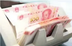  ??  ?? Chinese yuan notes are in a counting machine at a forex shop in Beijing. — AFP