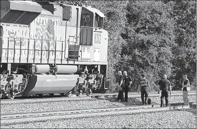  ?? Arkansas Democrat-Gazette/STATON BREIDENTHA­L ?? Emergency personnel investigat­e an accident Friday morning in which a pedestrian was hit and injured by a train in Little Rock near Geyer Springs Road and West 65th Street.