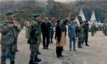  ?? — PTI ?? Defence minister Nirmala Sitharaman acknowledg­ing a row of Chinese soldiers from across the fence who were taking pictures of her reaching Nathu La