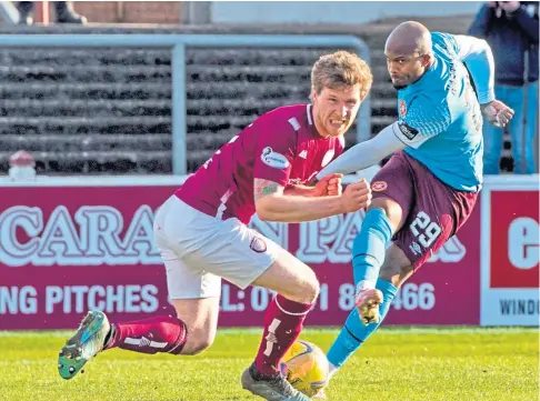  ??  ?? NO WAY THROUGH: Arbroath’s Colin Hamilton blocks a shot from Hearts midfielder Gervane Kastaneer.