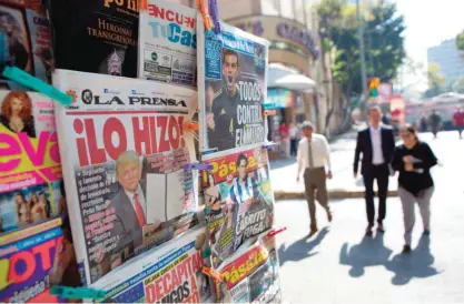  ??  ?? MEXICO CITY: A front page newspaper headline reads “He did it!” over a picture of US President Donald Trump holding up signed documents, as he took action to jumpstart constructi­on on a promised border wall, in Mexico City. — AP