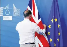  ?? — Reuters ?? An official adjusts a Union Jack flag next to the EU flag, ahead of a meeting between Britain’s Secretary of State for Exiting the European Union, Dominic Raab, and European Union’s chief Brexit negotiator, Michel Barnier, in Brussels on Thursday.
