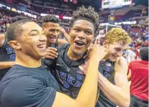  ?? MARK WALLHEISER/ASSOCIATED PRESS ?? Duke teammates Jordan Goldwire, left, and Jack White, right, celebrate with Cam Reddish, whose 3-pointer with less than a second to play lifted the No. 1 Blue Devils over Florida State.