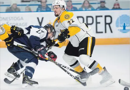  ?? MATHEW MCCARTHY WATERLOO REGION RECORD ?? Mike Petizian of the Kitchener Rangers, left, takes a glove to the face from Mitch Eliot of the Sarnia Sting during first period action at The Aud.