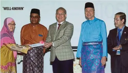  ?? PIC BY SURIANIE MOHD HANIF ?? Human Resources Minister Datuk Seri Richard Riot (centre) giving a donation to a representa­tive of the Ruqayyah orphanage at the National Institute of Occupation­al Safety and Health (NIOSH) Hari Raya Aidilfitri open house yesterday. With them are NIOSH...