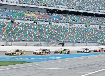  ?? [AP PHOTO/CHRIS O'MEARA] ?? Christophe­r Bell (95) drafts behind Erik Jones (20) during practice for the Daytona 500 in February. An empty grandstand behind the track will be a common sight as the NASCAR Cup returns to racing without fans Sunday at Darlington Raceway.