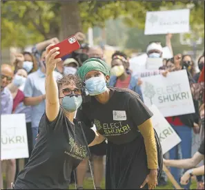  ?? (AP/Karen Ducey) ?? Shukri Olow (center right), a Muslim woman who is running for King County Council District 5, poses for a selfie photo with supporter Samia El-Moslimany (center-left), on Aug. 14 at a rally at a park in Renton, Wash., south of Seattle.