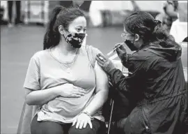  ?? Gary Coronado Los Angeles Times ?? NICOLE FAHEY of Altadena, who is six months pregnant, receives a Pfizer vaccinatio­n booster shot from nurse Veronique Vida in Los Angeles on Nov. 3.