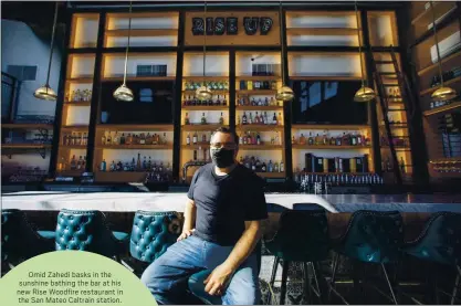  ?? KARL MONDON — STAFF PHOTOGRAPH­ER ?? Omid Zahedi basks in the sunshine bathing the bar at his new Rise Woodfire restaurant in the San Mateo Caltrain station.