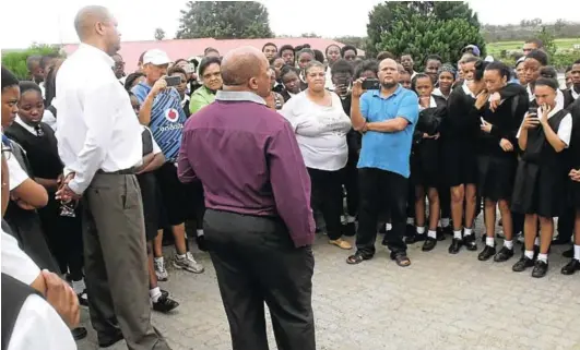  ?? Picture: DESMOND COETZEE ?? NO ENTRY: Breidbach Secondary School principal Les Mara, staff members and pupils of his school found themselves locked out of the school premises after parents locked gates last Friday. Mara and his deputy Morris Jagers address parents and pupils on...