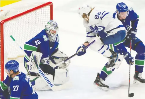  ?? ARLEN REDEKOP/POSTMEDIA NEWS ?? Vancouver Canucks' Braden Holtby makes a save in front of Toronto Maple Leafs' William Nylander and Canucks Tyler Myers at Rogers Arena Sunday night.