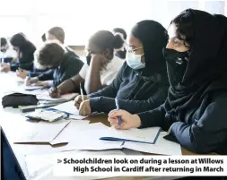  ??  ?? > Schoolchil­dren look on during a lesson at Willows High School in Cardiff after returning in March