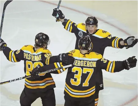  ?? STAFF PHOTO BY STUART CAHILL ?? TEAM EFFORT: Brad Marchand (top) celebrates his goal with linemates David Pastrnak and Patrice Bergeron during the Bruins’ 4-1 victory against the Montreal Canadiens last night at the Garden.