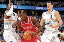  ?? David Zalubowski / Associated Press ?? The Rockets’ Clint Capela, center, who had 24 points, goes up against the Nuggets’ Paul Millsap, left, and Nikola Jokic.