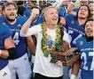  ?? Tony Avelar/Associated Press ?? Coach Brent Brennan holds the Dick Tomey Legacy trophy after defeating Hawaii.