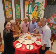  ?? ?? Tiong (third right) and Wee (second right) are joined by John (centre), Lee (left) and others in tossing yee sang for a prosperous year ahead, at the opening of Nyonya Kitchen by Sonia.