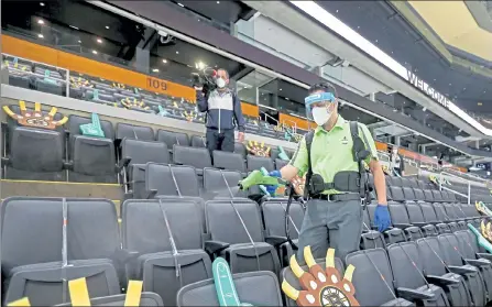  ?? STUART CAHILL PHOTOS / BOSTON HERALD ?? Garden employees spray down a section with disinfecta­nt Wednesday as the TD Garden prepares to open today for the first time with a limited number of fans.