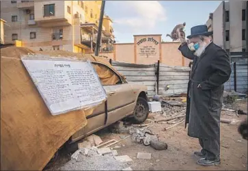  ?? AN ULTRA- ORTHODOX Oded Balilty Associated Press ?? Jewish man conducts a Yom Kippur ritual in Israel this week. An increase in coronaviru­s infections has caused a second lockdown in the country and a f ight over closing synagogues.