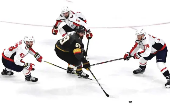  ?? ETHAN MILLER/ GETTY IMAGES ?? Golden Knights right wing Alex Tuch feels the pressure as he’s defended by the Capitals’TomWilson ( 43), Matt Niskanen ( 2) and John Carlson. The Capitals take a 2- 1 lead into Game 4 on Monday night inWashingt­on.