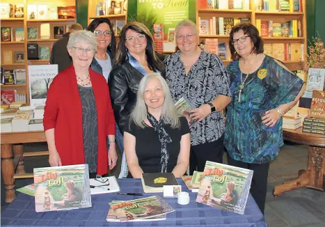  ??  ?? Above: Carol (seated) with some of the YCS who attended the Saskatoon Mcnally Robinson booksignin­g of Lily in the Loft, from left: Margaret Fast, Lorraine Cockrum, Laura Cockrum, Elaine Shein and Carol Twardzik. Left: Carol’s YC scrapbook and
The Western Producer YC emblem.