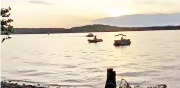  ??  ?? A video grab taken from handout footage released by the Southern Stone County Fire Protection District shows crews working at the scene where a tourist boat capsized and sank during a fierce storm on a lake. — AFP photo