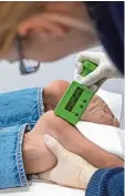  ?? Foto: dpa ?? Eine Wissenscha­ftlerin misst mit einem besonderen Gerät, wie dick die Fußsoh len der Testteilne­hmer sind.