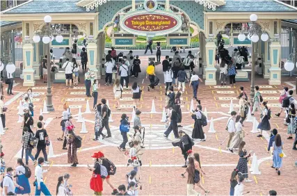  ??  ?? Visitors practise social distancing while waiting to enter Tokyo Disneyland in Urayasu, east of Tokyo yesterday.