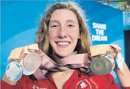  ?? RYAN REMIORZ THE CANADIAN PRESS ?? Canada’s Taylor Ruck holds up her eight swimming medals at the Commonweal­th Games on Tuesday in Gold Coast, Australia.