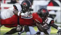  ?? Arkansas Democrat-Gazette/MITCHELL PE MASILUN ?? Southeast Missouri State strong safety Marcus Lucas (left) and cornerback Shabari Davis tackle Arkansas State running back Marcel Murray during Saturday’s game at Centennial Bank Stadium in Jonesboro. The Red Wolves will work to improve several areas as they prepare for Alabama on Saturday.