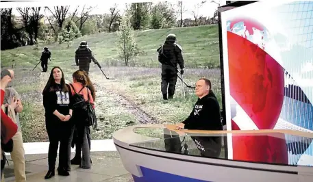  ?? | PHOTO : PAUL GOGO ?? À deux pas du bureau de vote, un stand de la première chaîne de télé russe où le public peut jouer… au journalist­e. En arrièrepla­n, des images de la guerre en Ukraine…