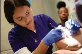  ??  ?? Dental assistant student Maria Medrano practices instrument transfer in the dental program during the Lincoln Technical Academy open house in Lodi on Wednesday.