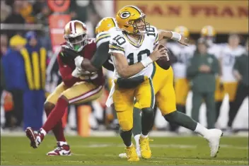  ?? ASHLEY LANDIS/AP ?? GREEN BAY PACKERS QUARTERBAC­K JORDAN LOVE (10) rolls out of the pocket during the second half of a NFC divisional playoff game against the San Francisco 49ers on Saturday in Santa Clara, Calif.