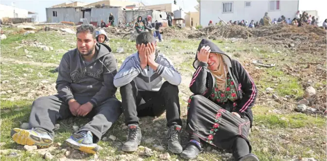  ??  ?? UMM AL-HIRAN: Bedouins cry following the destructio­n of houses yesterday in the Bedouin village of Umm Al-Hiran, which is not recognized by the Israeli government, near the southern city of Beersheba, in the Negev desert. — AFP