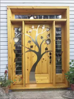  ??  ?? Tree door - A youthful symbol of beauty and happiness, the apple tree is a fitting design for this custom front door.