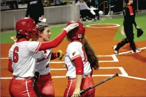  ?? Mark Humphrey/Enterprise-Leader ?? Teammates congratula­te Farmington’s Justine Davidson after her sacrifice fly drove in a run to give the Lady Cardinals 1-0 lead against Pea Ridge in the 4A-1 District softball tournament semifinals Thursday. Pea Ridge rallied late to win, 7-3, dropping Farmington into Friday’s consolatio­n game which they won, 8-5, over Gentry.