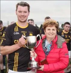  ??  ?? Adamstown captain Colm Boland receiving the cup from Mary Foley.