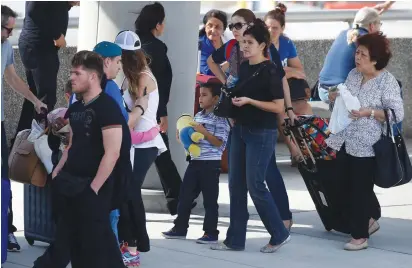 ?? (Carlo Allegri/Reuters) ?? PASSENGERS WAIT in long lines outside a terminal at Ft. Lauderdale Internatio­nal Airport yesterday, after it reopened following the shooting on Friday.