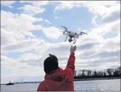  ?? Seth Wenig Associated Press ?? PARKER GYOKERES reaches for his drone after it snapped photos over Hart Island in New York.