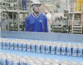  ?? KOJI SASAHARA/AP FILES ?? Asahi Breweries plant manager Shinichi Uno watches the production line in Moriya near Tokyo. Japanese workers generally welcome automation as jobs are stable amid fears of a labour shortage.