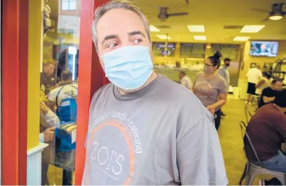  ?? MARK MIRKO PHOTOS/HARTFORD COURANT ?? Owner Peter Maniatis wears a mask at the entrance of his restaurant, Zoi’s, on the first day of New Haven’s citywide mask mandate for indoor spaces. The city is the first municipali­ty in Connecticu­t to reinstate the rule.